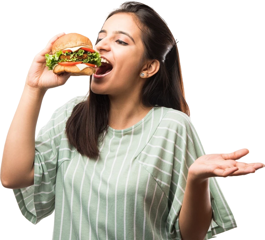 Attractive indian asian girl eating burger white yellow background