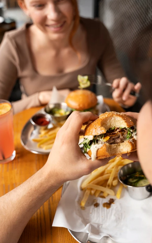 Medium shot friends eating fast food funny way